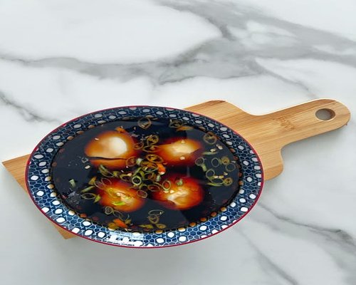 Soft boiled eggs with soy sauce on a marble table