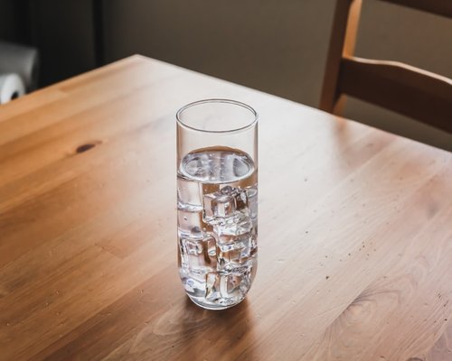 A glass of clear drinking water on a wooden table